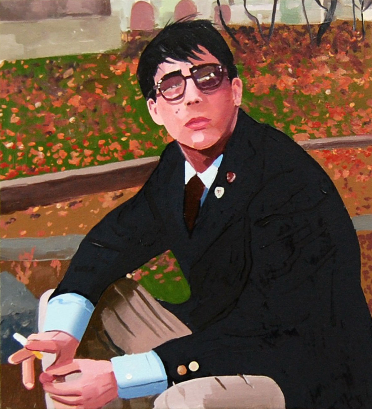 Seated man in a suit with glasses smoking a cigarette