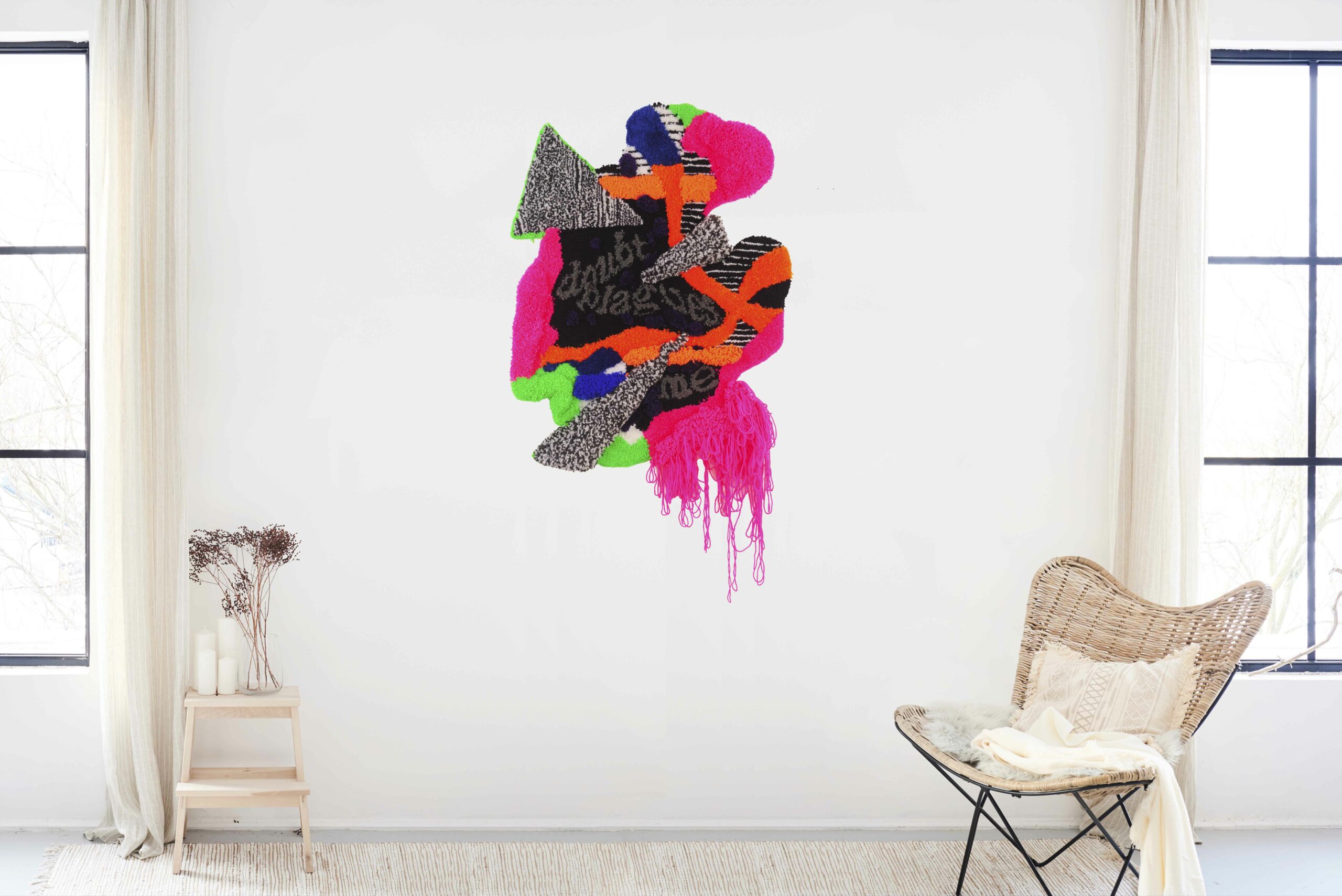 Fabric pieces glued together in abstract shapes in vibrant pink, blue, orange, green, black and gray with text