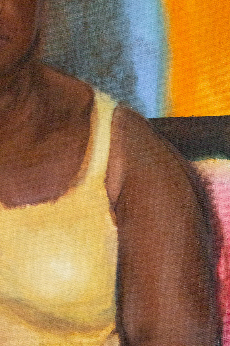 Seated woman facing out at viewer in yellow tank top