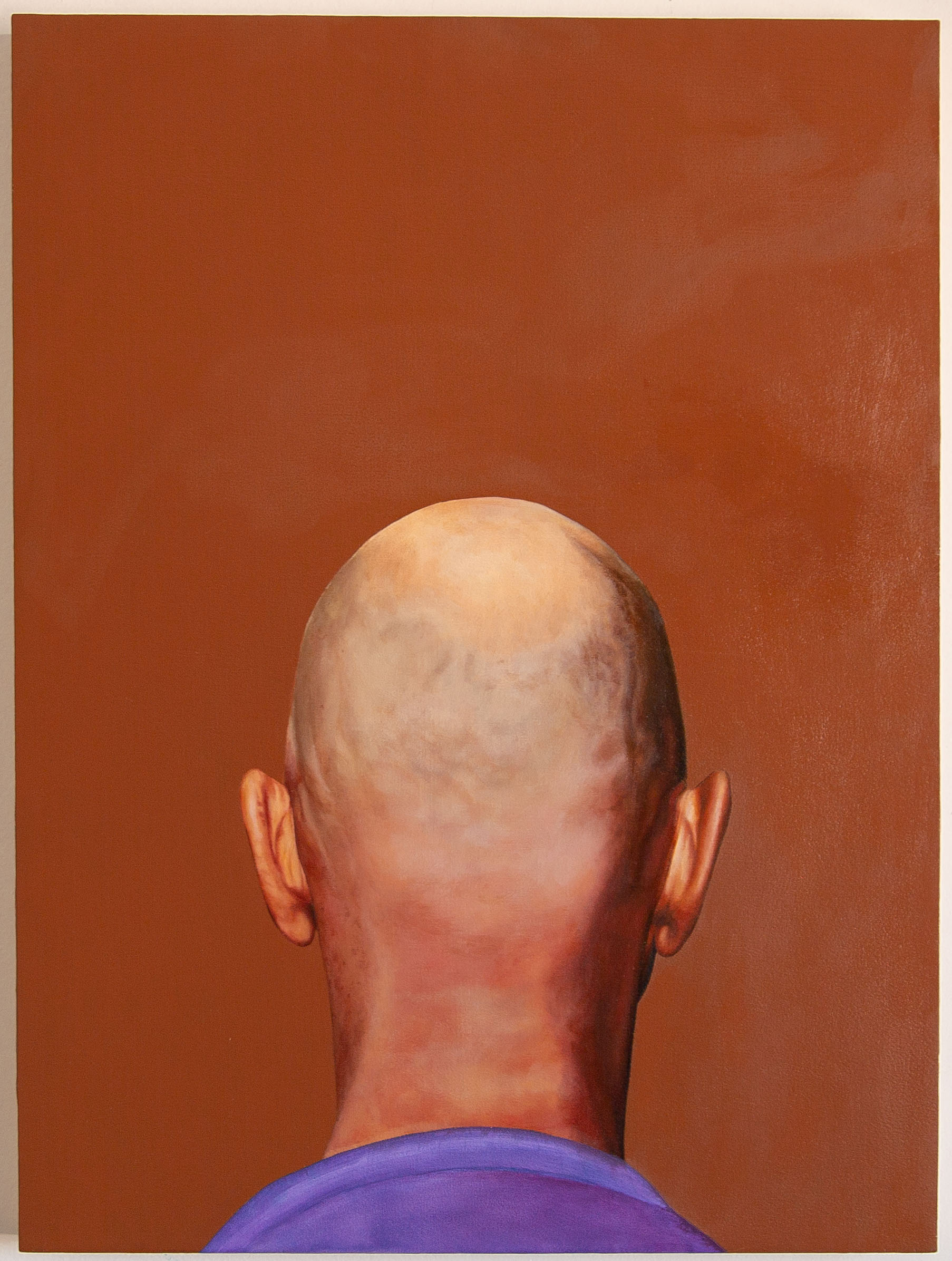 Back of shaved head against brown background